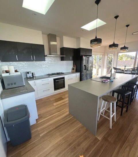 Modern kitchen with island bench and timber floors after a residential clean
