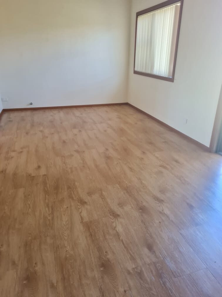 Empty bedroom with timber floors and skirting cleaned for handover