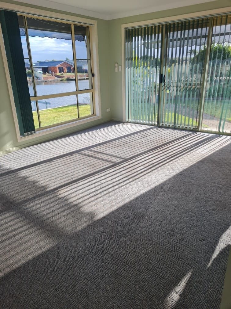 Sunlit lounge room with carpets cleaned before settlement