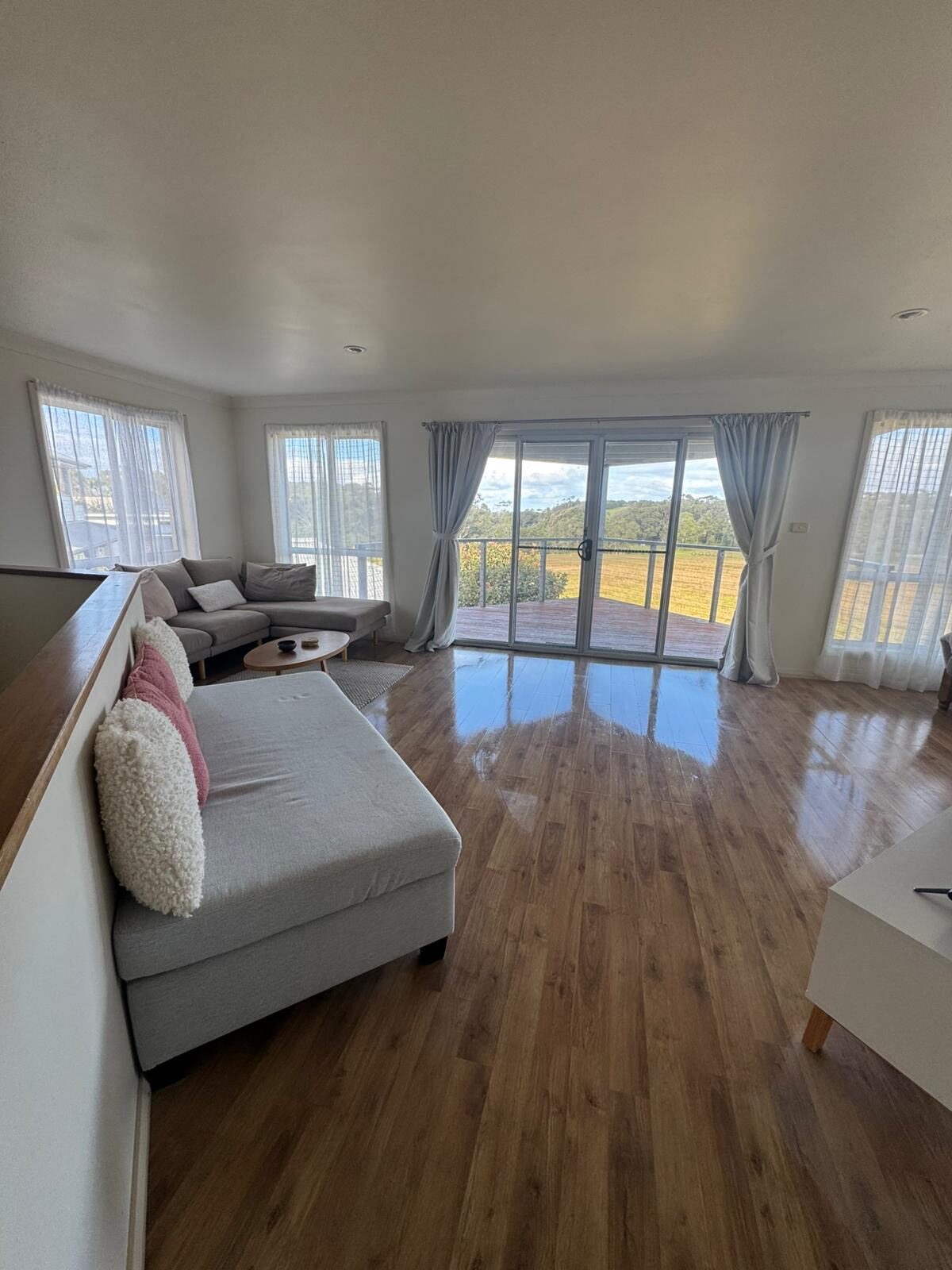 Open plan living room with polished floors ready for guests