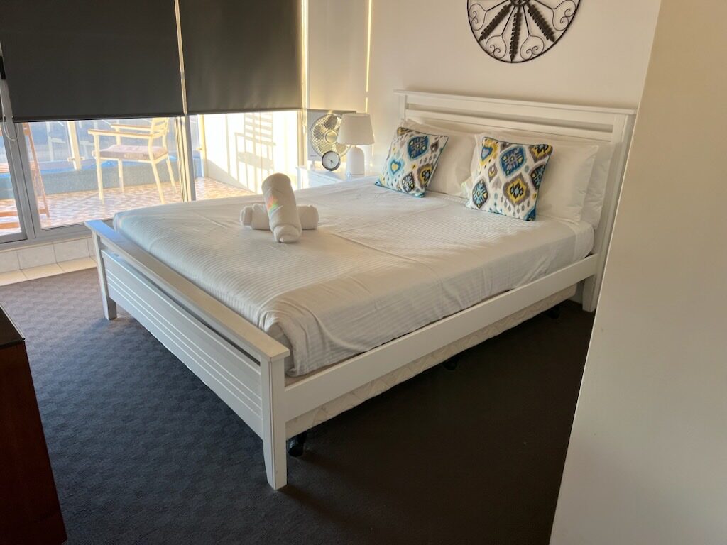 King bed made up with fresh linen and rolled towels